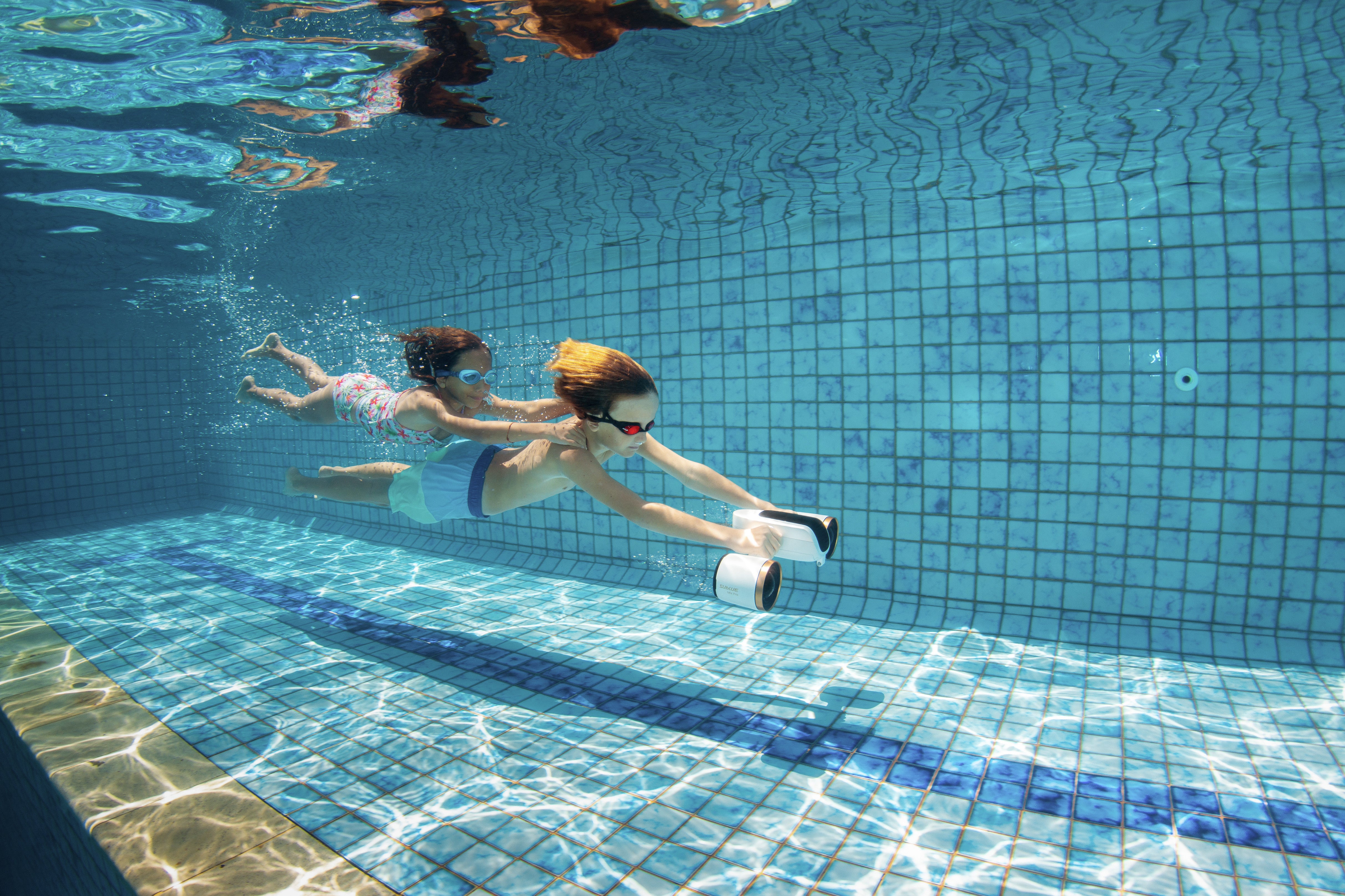 Underwater, holding a water scoote