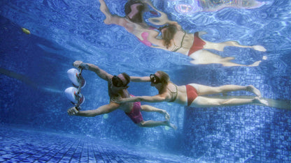 Two swimmers using Tini Double-Engine Support Handle underwater for propulsion.