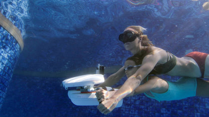 Diver using underwater scooter with Tini Floater attachment in a pool.