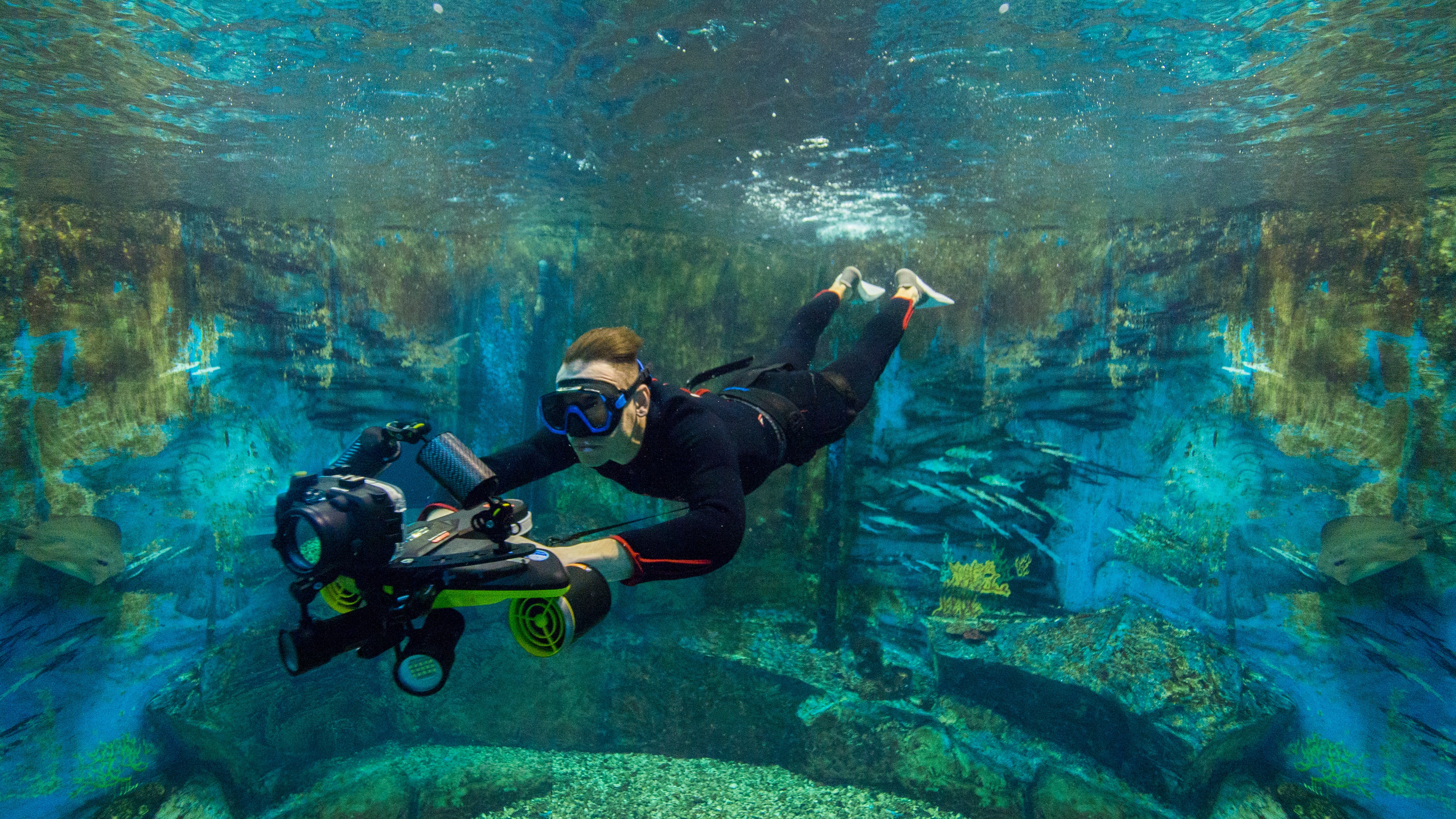 Diver using Navbow base plate with action camera underwater