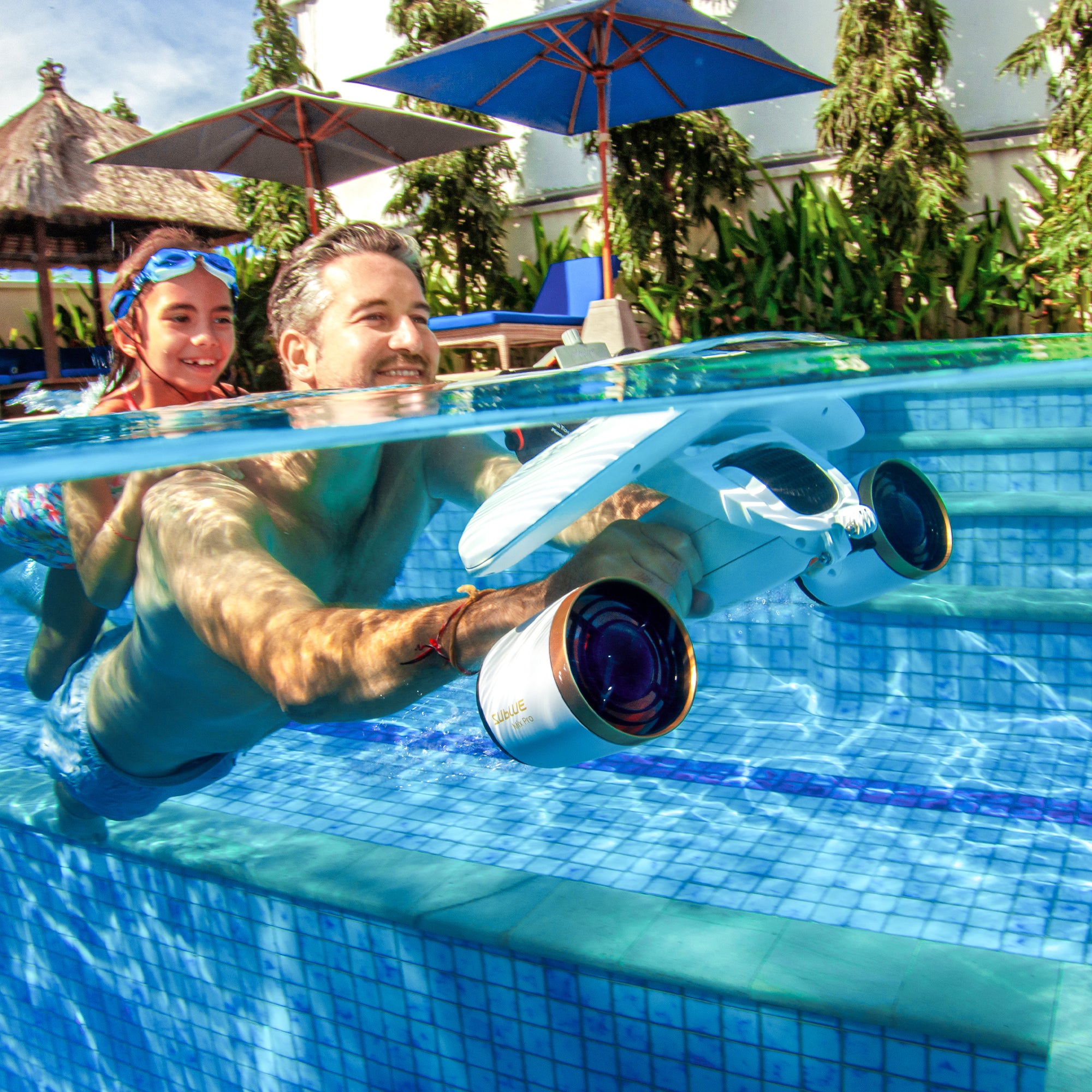 Adult and child using SUBLUE MixPro underwater scooter in a pool.