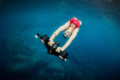 Swimmer using SUBLUE MixPro underwater scooter in clear blue water.