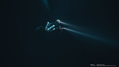 Diver with powerful underwater light illuminating dark depths for exploration.