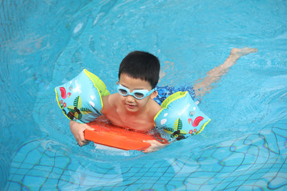 Child swimming with colorful inflatable armbands in blue pool