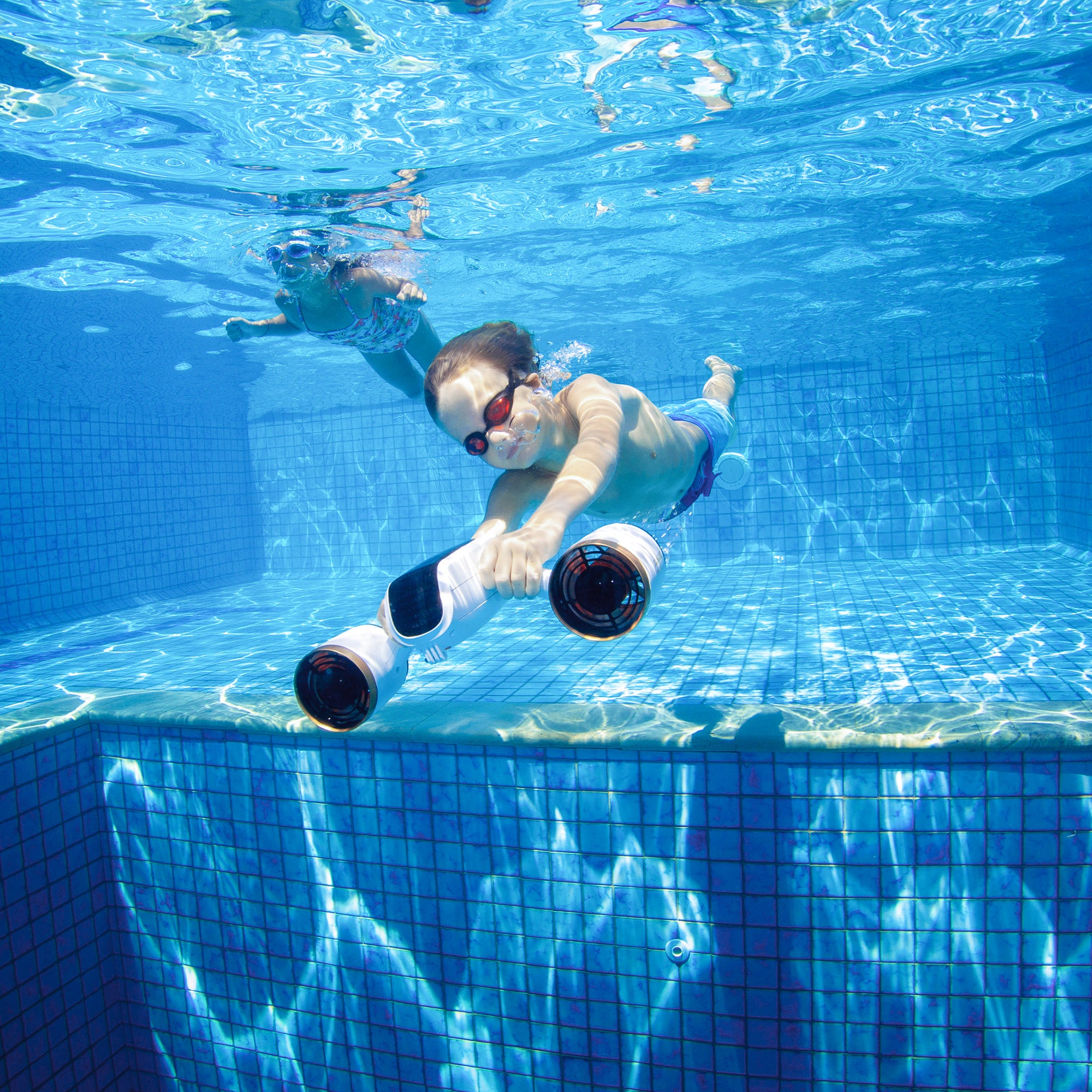 Child gliding underwater with SUBLUE MixPro scooter in a bright pool.