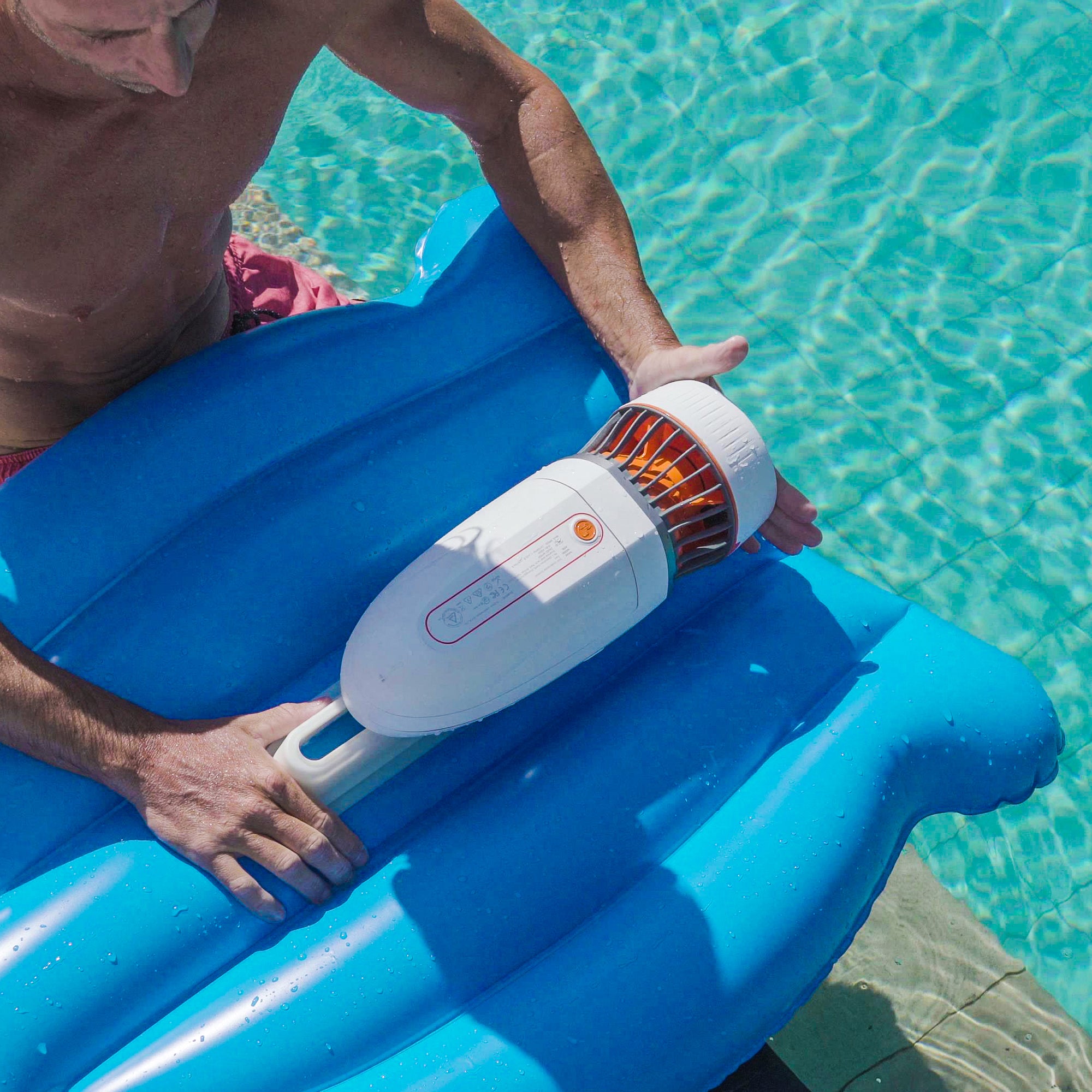 Person enjoying Tini inflatable kickboard with underwater scooter in clear water.