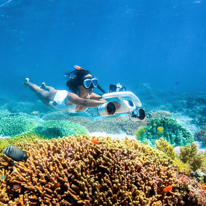 Diver using SUBLUE MixPro underwater scooter near vibrant coral reef.