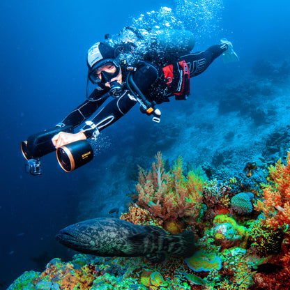 Diver using SUBLUE MixPro underwater scooter near colorful coral reef