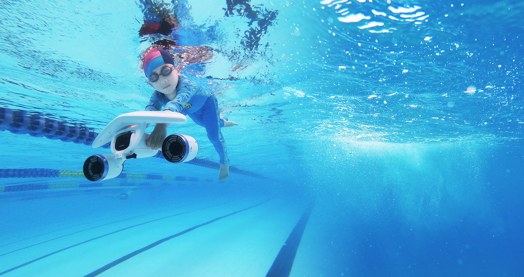 Child using SUBLUE Mix underwater scooter while swimming in a pool