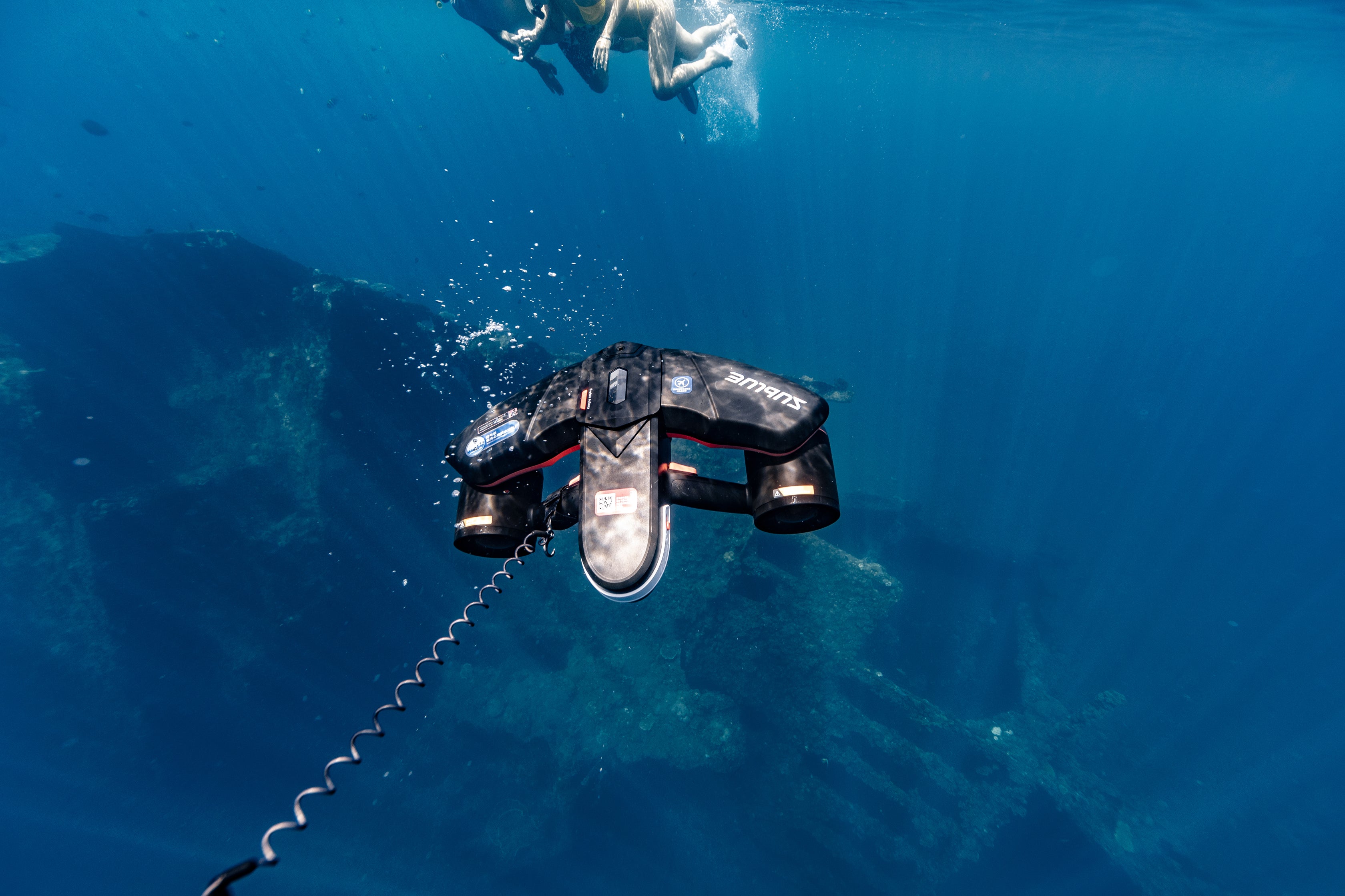 Sublue underwater scooter with anti-lost lanyard in deep blue water.