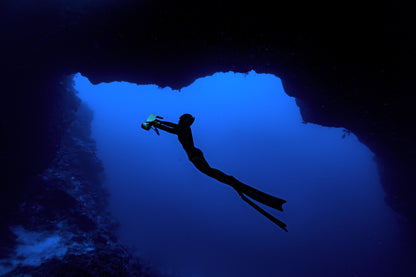 Diver exploring underwater cave with Sublue underwater scooter.