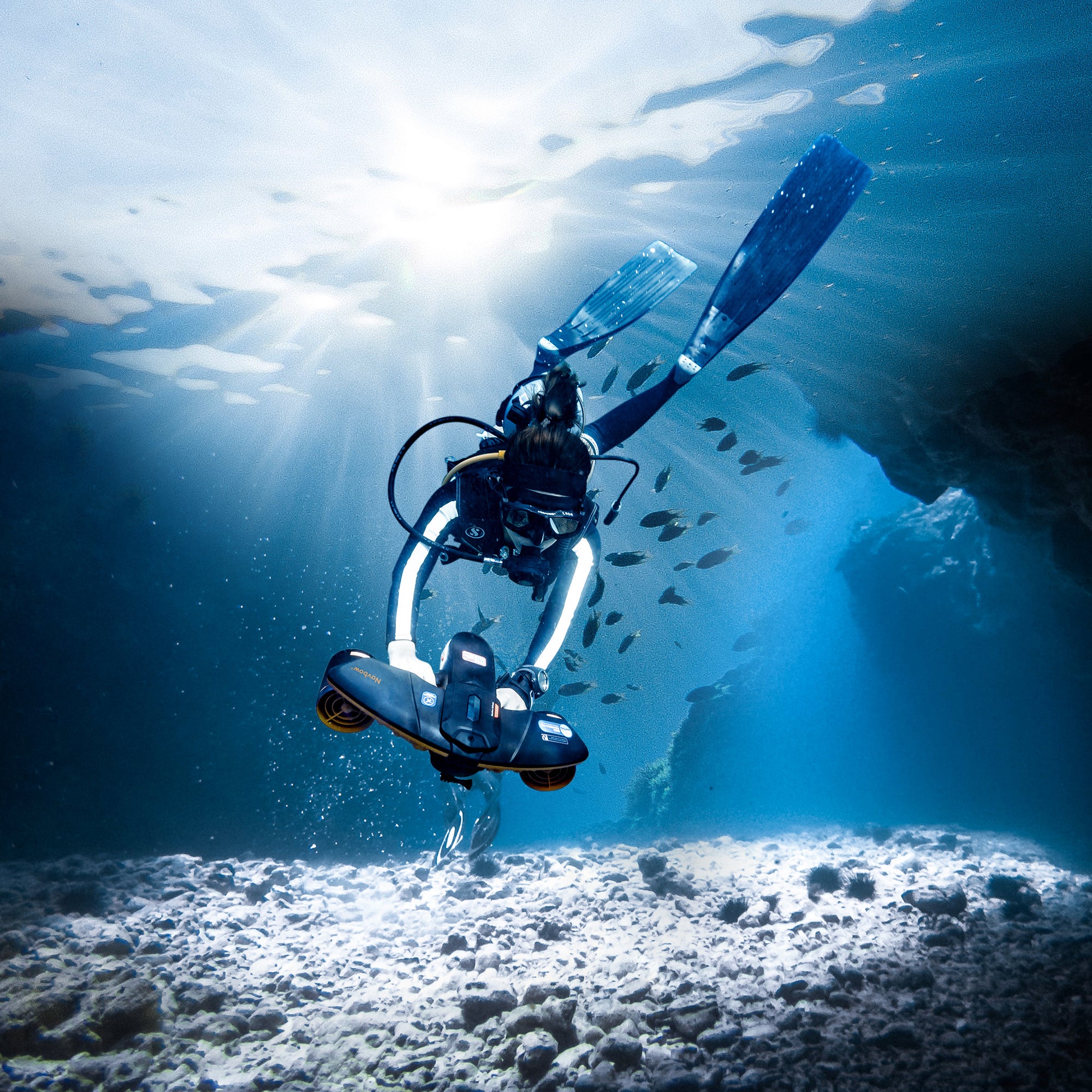 Diver using SUBLUE Navbow+ scooter exploring underwater landscape with sunlight