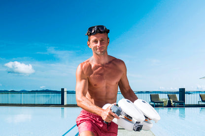 Man holding Tini Floater near pool ready for underwater exploration.