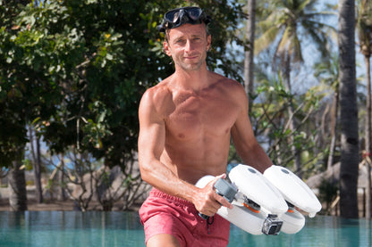 Man ready for underwater exploration with Tini Floater attachment by the pool.