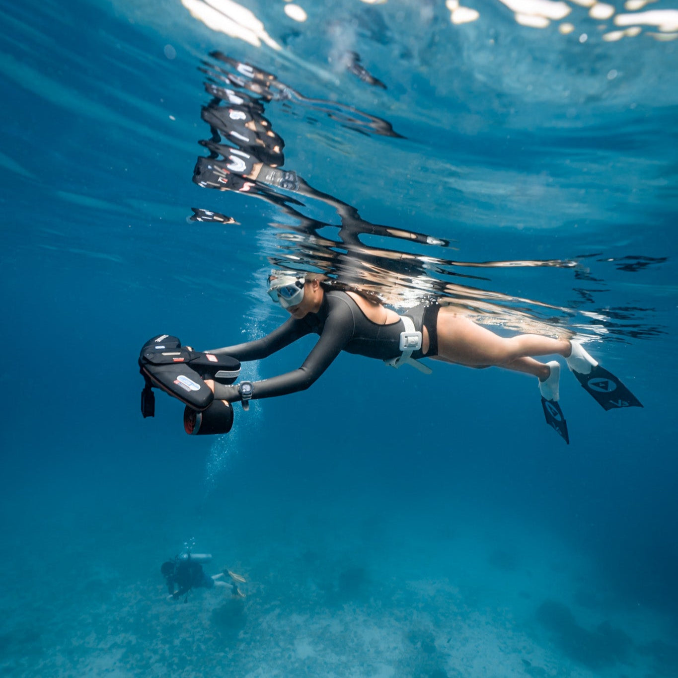 User maneuvering SUBLUE Navbow underwater scooter in clear ocean water