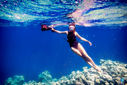 Diver using Sublue underwater scooter while exploring colorful coral reefs.