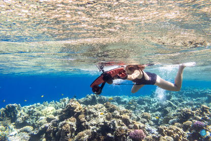 Diver using Sublue underwater scooter in a vibrant coral reef.