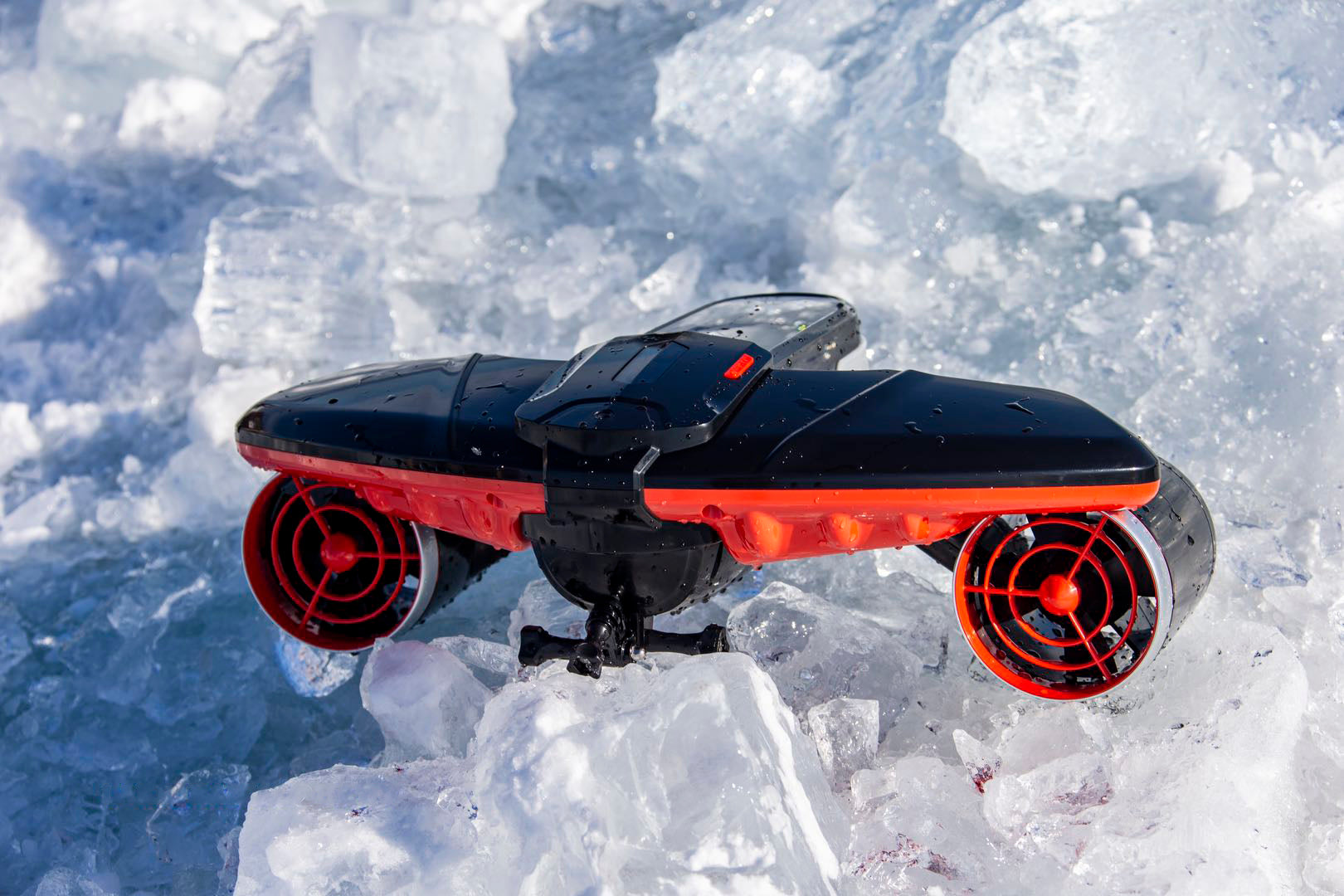 Sublue Navbow underwater scooter on icy surface with black and red design.