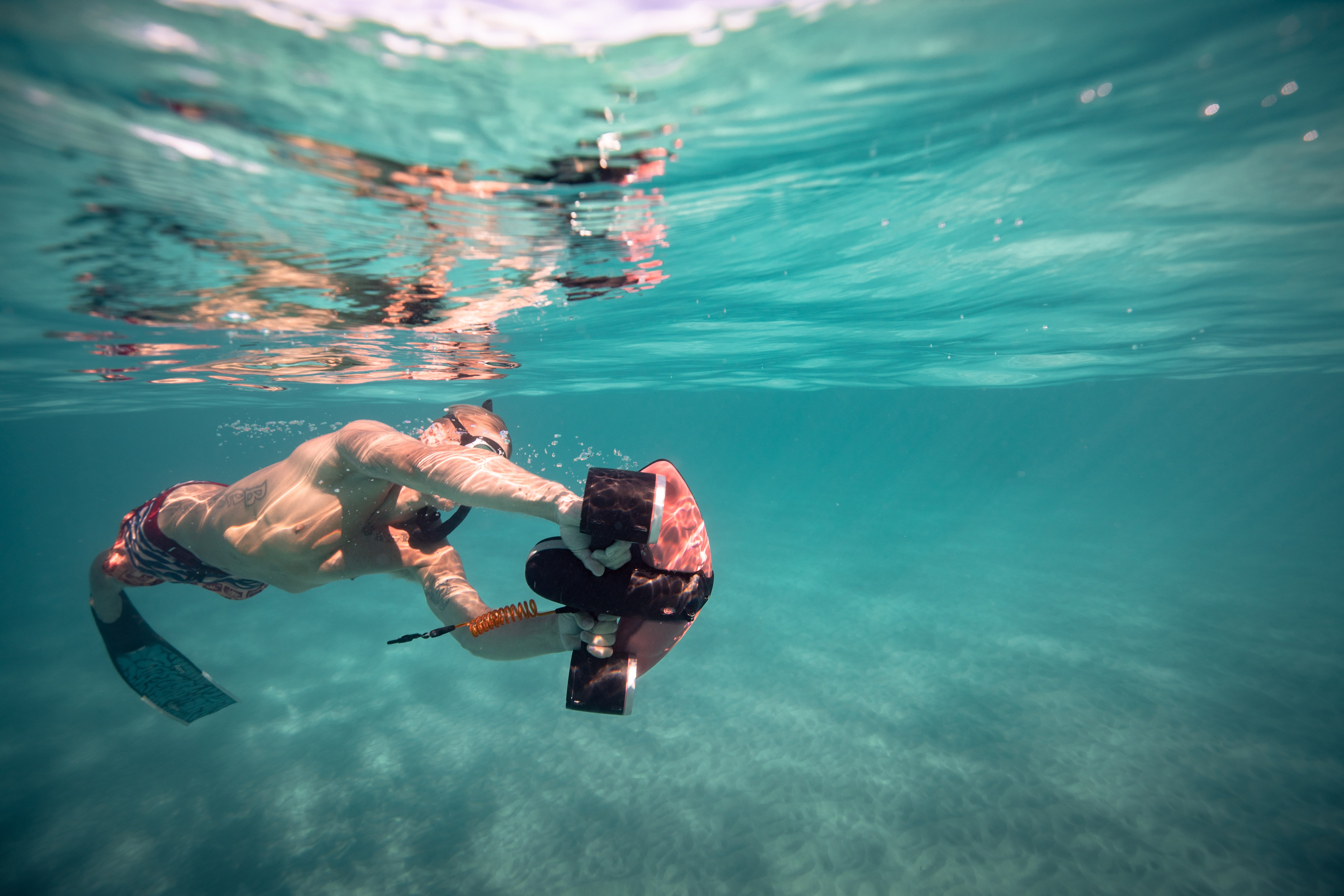 Diver using SUBLUE Navbow underwater scooter in clear water.