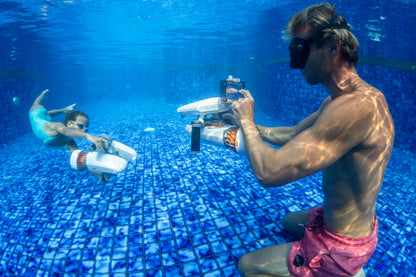 Diver photographing a friend underwater with Sublue H1 phone case and scooter.