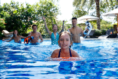 Child swimming with SUBLUE Swii kickboard, family enjoying water fun in a pool.